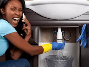 Emergency plumbing repair for a leaking sink drain under a bathroom vanity in Des Moines, IA