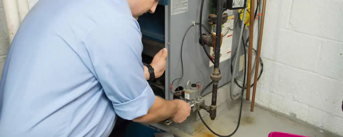 Furnace repair technician inspecting and servicing a home heating system in Des Moines, IA