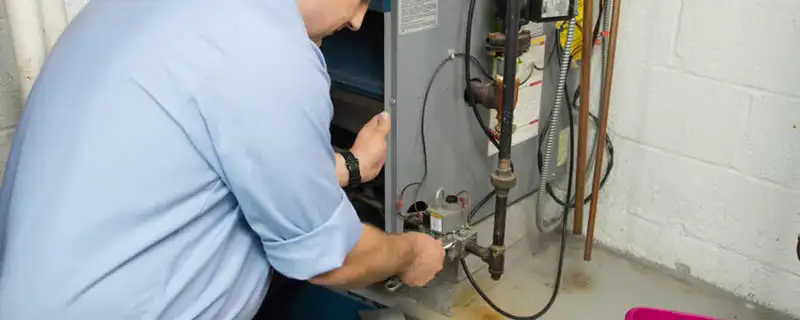 Furnace repair technician inspecting and servicing a home heating system in Des Moines, IA