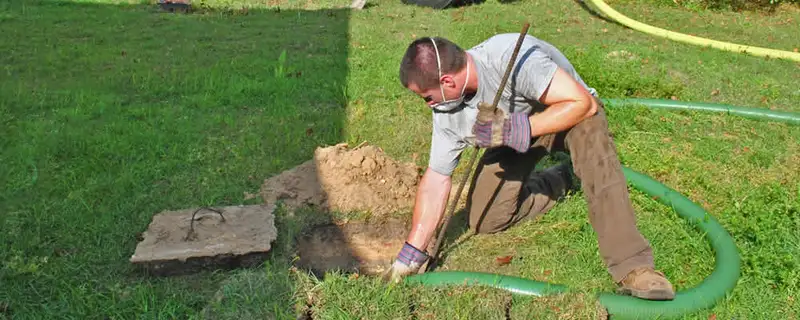 Septic pumping technician servicing a residential septic tank in Des Moines, IA