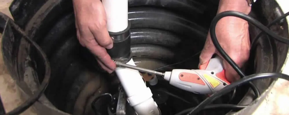 Sump pump installation technician connecting PVC discharge piping in Des Moines, IA